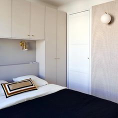 a bedroom with white cabinets and a black bed