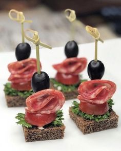 small sandwiches topped with meat and black olives