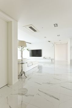 a living room with marble floors and white walls