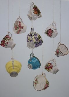 a bunch of tea cups hanging from strings