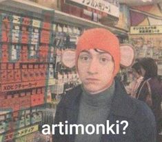 a man wearing a monkey hat in a store with the caption artmonki?