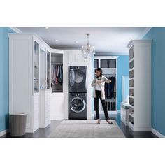 a woman standing in front of a washer and dryer