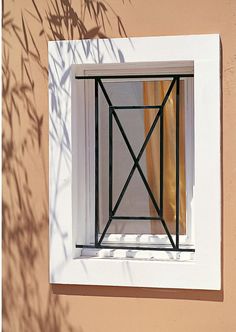 the shadow of a plant is seen through an open window in a house's exterior