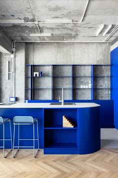 an empty kitchen with blue cabinets and stools