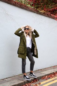 Lucy Williams shows us how to wear the Parka trend, pairing this khaki jacket with black mom jeans and sneakers. Parka: Topshop, T-Shirt: Maison Labiche via Sezane, Jeans: Topshop, Trainers: Vans. Vans Sk8 Hi Black, How To Wear Vans, Fashion Me Now, How To Wear Sneakers, Green Parka