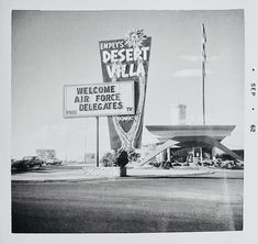 an old black and white photo of a desert walla sign