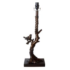 a candle holder with a bird on it and a tree branch in the middle that is holding two candles