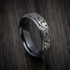 a wedding ring with an intricate design on the inside and outside, sitting on a wooden surface