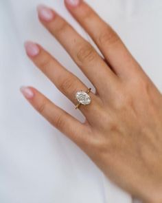 a woman's hand with a diamond ring on it