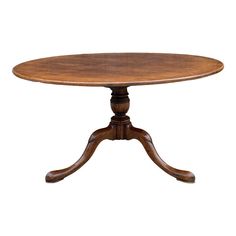 an oval wooden table with four legs and two leaves on each end, in the middle of