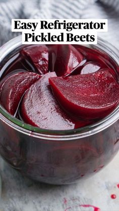 a glass jar filled with beets on top of a table