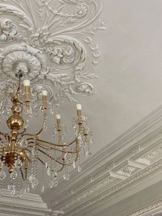 a chandelier hanging from the ceiling in a room with white walls and ceilings