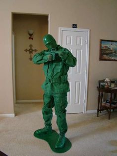 an image of a man dressed as a green army man in the middle of a room