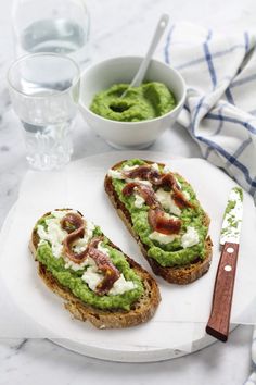 two pieces of bread with guacamole and bacon on them