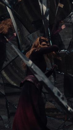 a woman with long red hair holding two swords