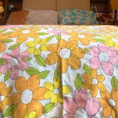 a bed with yellow and pink flowers on it