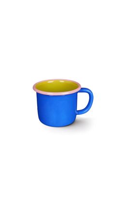 a blue and yellow cup sitting on top of a white table