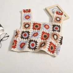 a crocheted top and glasses on a table