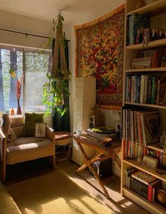 a living room filled with furniture and bookshelves next to a window covered in plants