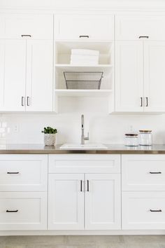 a kitchen with white cabinets and stainless steel appliances