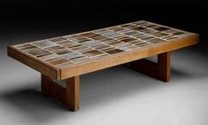 a coffee table made out of wood and glass tiles