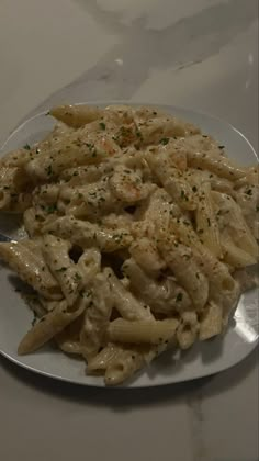 a white plate topped with pasta covered in sauce