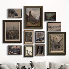 a living room filled with lots of framed pictures on the wall next to a couch