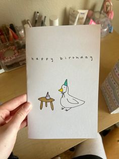 someone holding up a birthday card with a duck on it