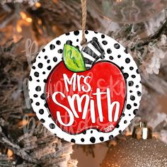 a christmas ornament hanging from a tree with polka dots and an apple on it