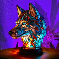 a stained glass wolf lamp sitting on top of a wooden table