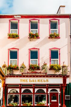 the exterior of a building with red and white shutters on it's windows