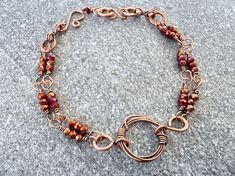 a close up of a bracelet with beads and chains on a gray carpeted surface