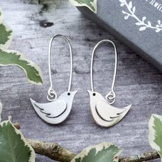 POSTAL DELAYS ARE COMMON DURING DECEMBER AND SADLY I CAN NOT GUARANTEE YOUR ORDER WILL ARRIVE IN TIME FOR CHRISTMAS.    These super cute sterling silver bird dangle earrings have been designed and handmade completely from scratch and entirely by hand using traditional silversmithing techniques in my Sussex (UK) workshop.   These little birds and their wing decoration are hand pierced (sawn out) from sterling silver sheet using a fine jewellers saw.   All components are then silver soldered together.   They have been oxidised to enhance features of their design.  The birds measure approximately 17.5mm wide by 12.3mm high (including the jump ring) and hang from hand made sterling silver ear wires so that the total drop length from the top of the ear wires are approximately 3.5cm.   If you wo Silver Dangle Jewelry With Bird Design, Nickel Free Sterling Silver Jewelry In Bird Shape, Silver Bird-shaped Earrings For Pierced Ears, Silver Bird Design Drop Earrings, Silver Drop Earrings With Bird Design, Silver Bird-shaped Earrings Gift, Handmade Sterling Silver Bird-shaped Jewelry, Silver Bird-shaped Earrings For Gift, Dangle Earrings With Bird Design For Gift