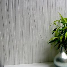 a potted plant sitting on top of a white shelf in front of a wall