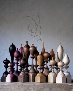 an assortment of vases sitting on top of a wooden table next to each other