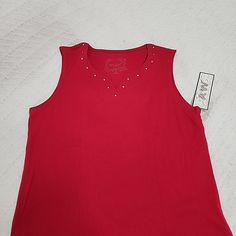 New With Tag Red Sleeveless Top With Studs Around Neckline Medium 60% Cotton/40% Polyester Red Stretch Sleeveless Tank Top, Red Cotton Tank Vest, Sleeveless Red Cotton Top, Red Stretch Tank Vest, Red V-neck Cotton Vest, Red Cotton Vest Tank Top, Red Cotton Vest Top, Casual Red Sleeveless Tank Top, Red Sleeveless Top