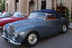 several classic cars parked in front of a building