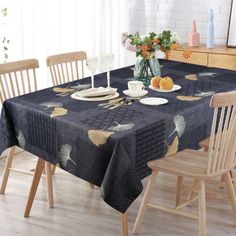 a dining room table with two chairs and a vase filled with oranges on it