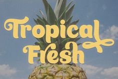 a pineapple with the words tropical flesh written on it's side in front of a blue sky