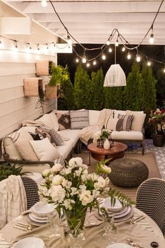 an outdoor living area with patio furniture and string lights