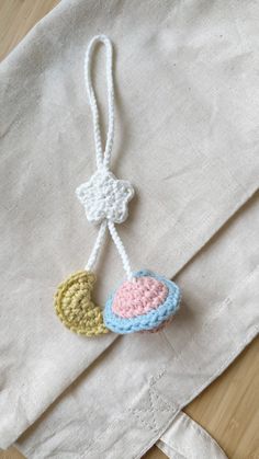 a crocheted ornament hanging from a white linen bag on a wooden table