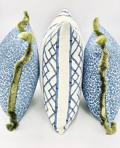 two blue and white pillows with green tassels