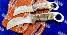 two knives are sitting on top of an orange and white cutting board that has been cut open