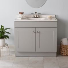 a bathroom with a sink, mirror and potted plant on the floor in front of it