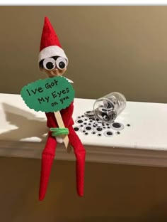 an elf is holding a sign that says i've got my eyes on you