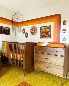 a crib and dresser in a child's room with an orange rug on the floor