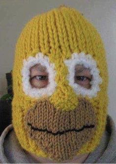 a man wearing a knitted yellow mask with white eyes