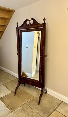 a mirror sitting on top of a wooden stand in front of a stair case next to a wall