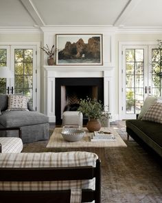 a living room filled with furniture and a fire place in front of a painting on the wall