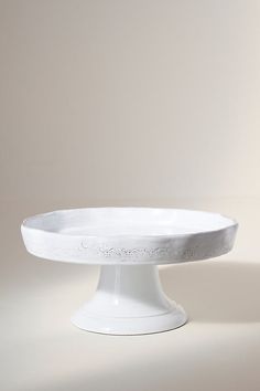 a white cake plate sitting on top of a table